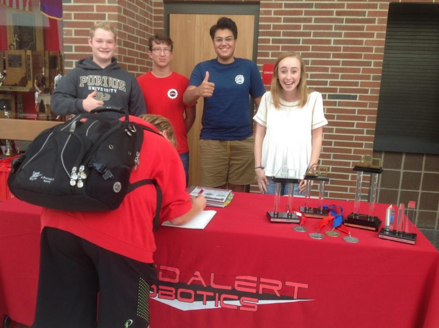 A student signs up for Red Alert Robotics with seniors Josh Stevenson, Kevin Beshears, Chase Rivas and Meredith Fain.