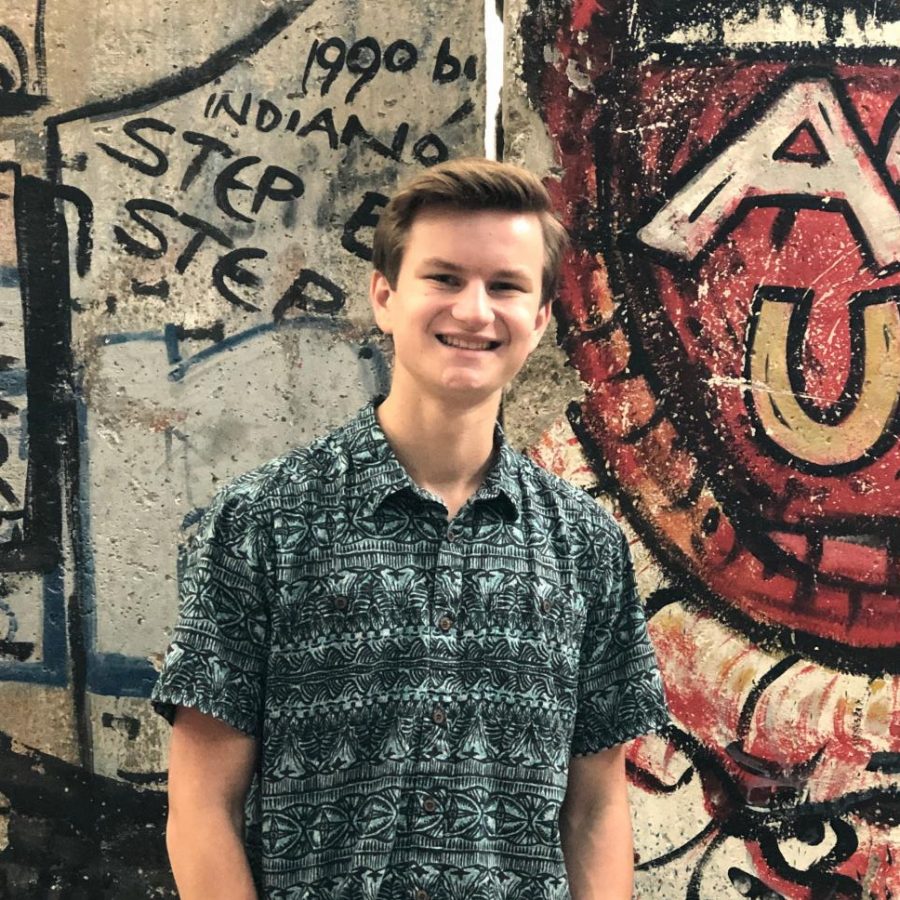 Senior Graham Kanwit stands in front of a portion of the Berlin Wall at the Newseum in Washington, DC.