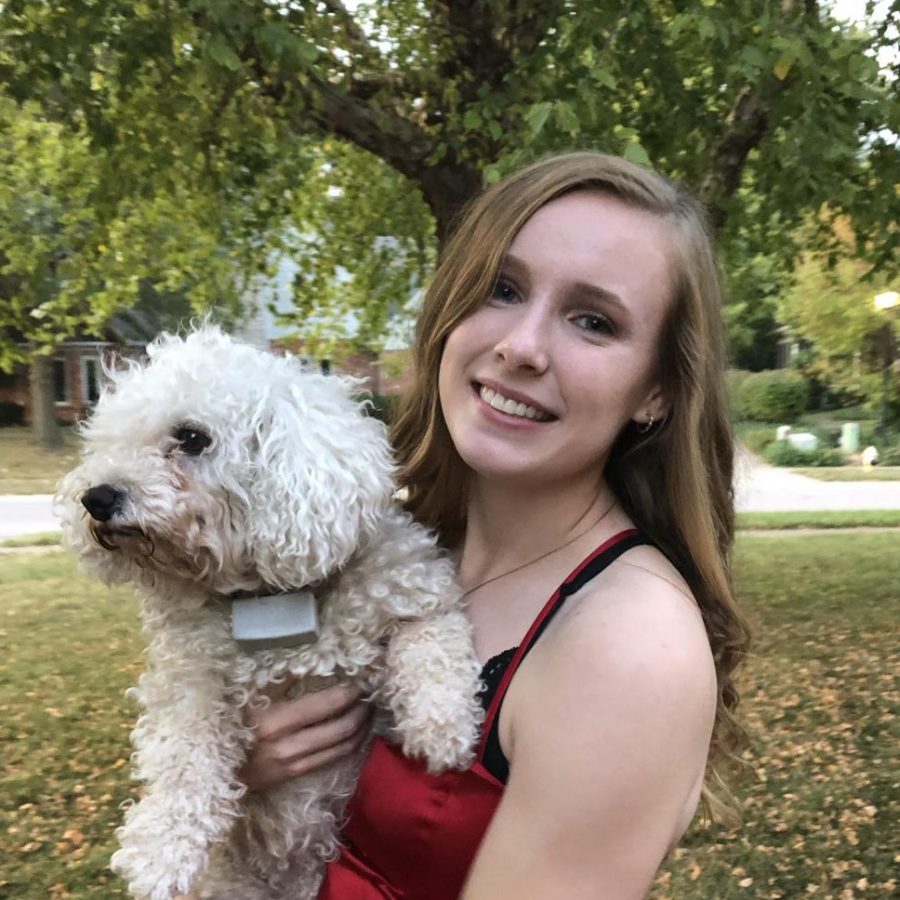 Senior Kelsey Osborne poses for a picture with a friends dog, Mya, before Homecoming 2019.