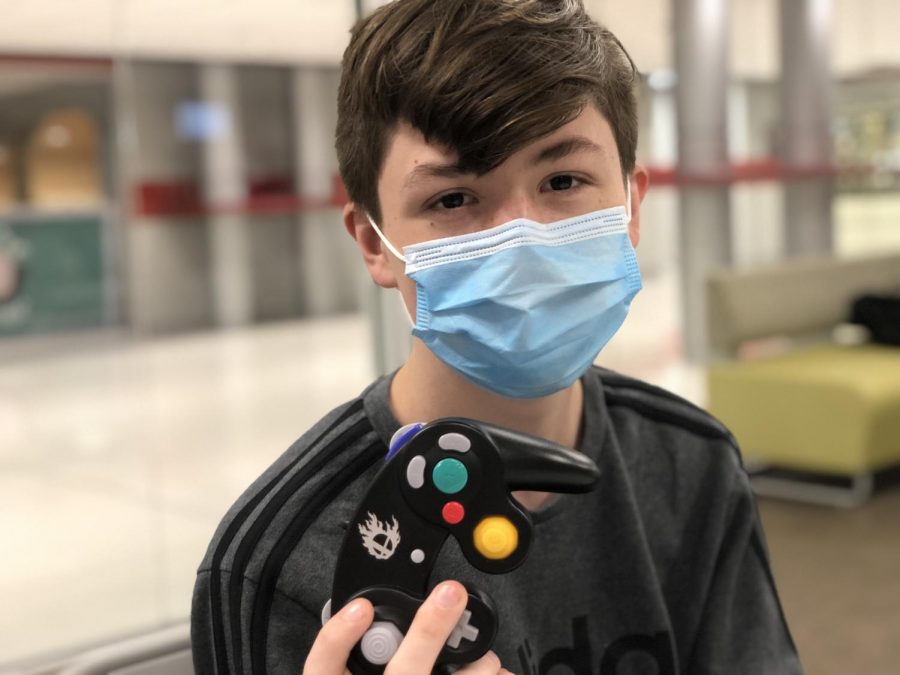 Sophomore Nick Thomas poses with his Smash Bros. GameCube controller that he uses to compete in tournaments. Thomas uses the controller due to its “snappy” joysticks that allow him to complete moves with ease and its “comfortable” layout.