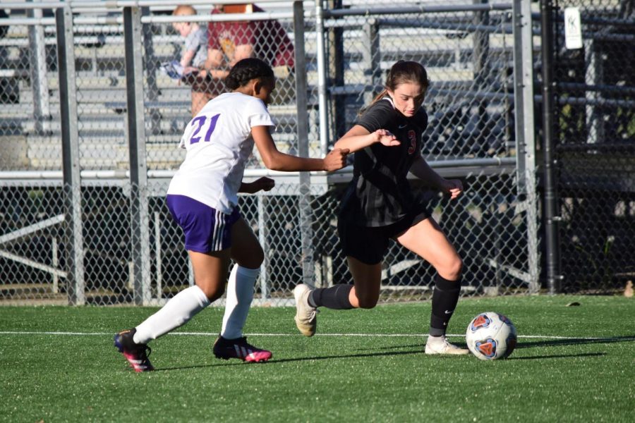 Junior Emily Karr dribbles the ball past a defender during the teams 9-0 win against Ben Davis.