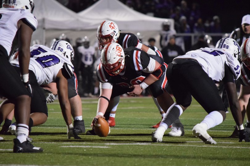 Offensive lineman Jacob Newlin snaps the ball during the Trojans semistate win against Ben Davis.