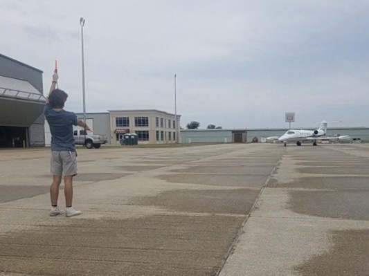 Senior Jesse Minton signals for an airplane at the Greenwood Airport. Photo contributed
