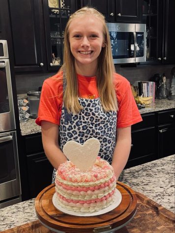 Junior Makenna Lulfs stands with a cake she baked and decorated.
