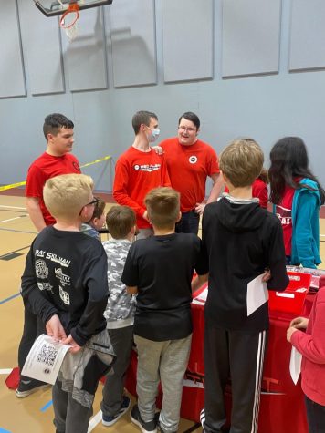 Eli Leser speaks to students at a robotics promotional table. Photo contributed