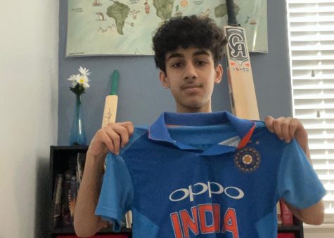 Thete holds up an Indian Cricket jersey.