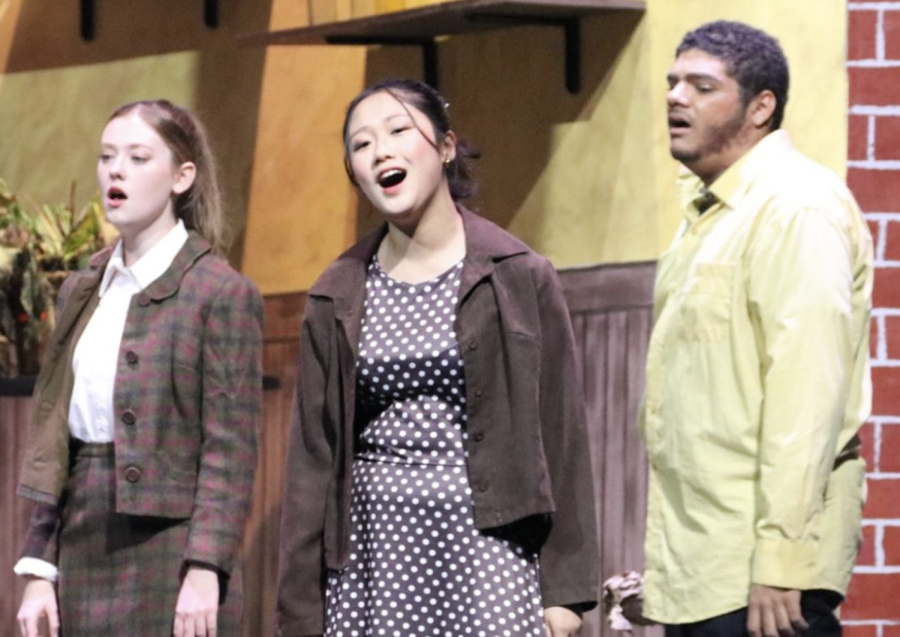 Freshman Momoka Miyazaki (middle) sings with the chorus during the fall musical production of Little Shop of Horrors.