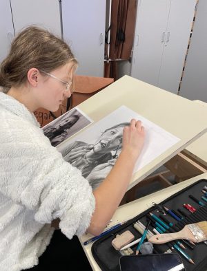 Sophomore Regan Dugan sketches a graphite art piece during her Drawing 1 class.