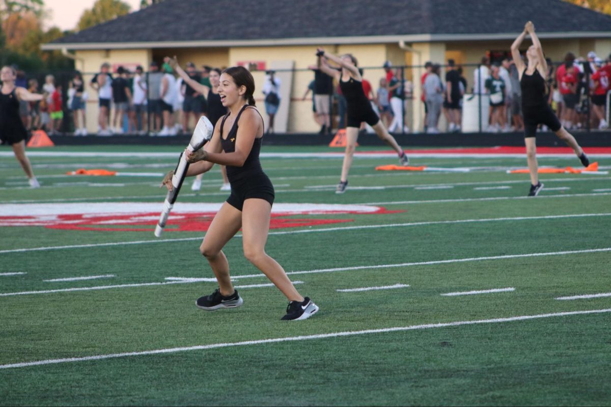 At the Sept. 1 football game, senior Ivanna Rodriguez performs the first part of the show at halftime without costume. Rodriguez, part of the weapon line, said, “I enjoyed doing this part of the show because we worked during band camp. It was my last time learning the beginning of a marching show and learning it and performing it meant something to me.”