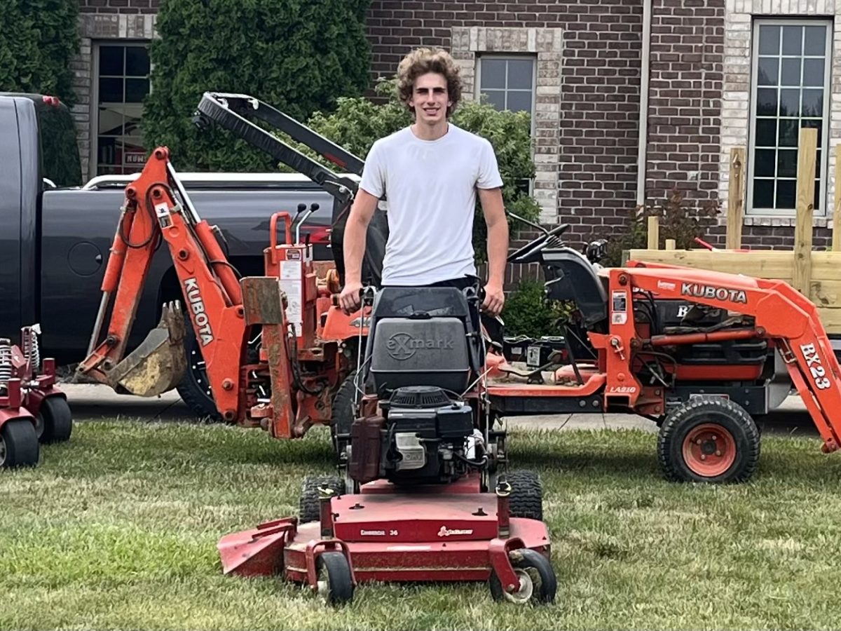 Senior Jack Matthews poses with his mowing equipment. 