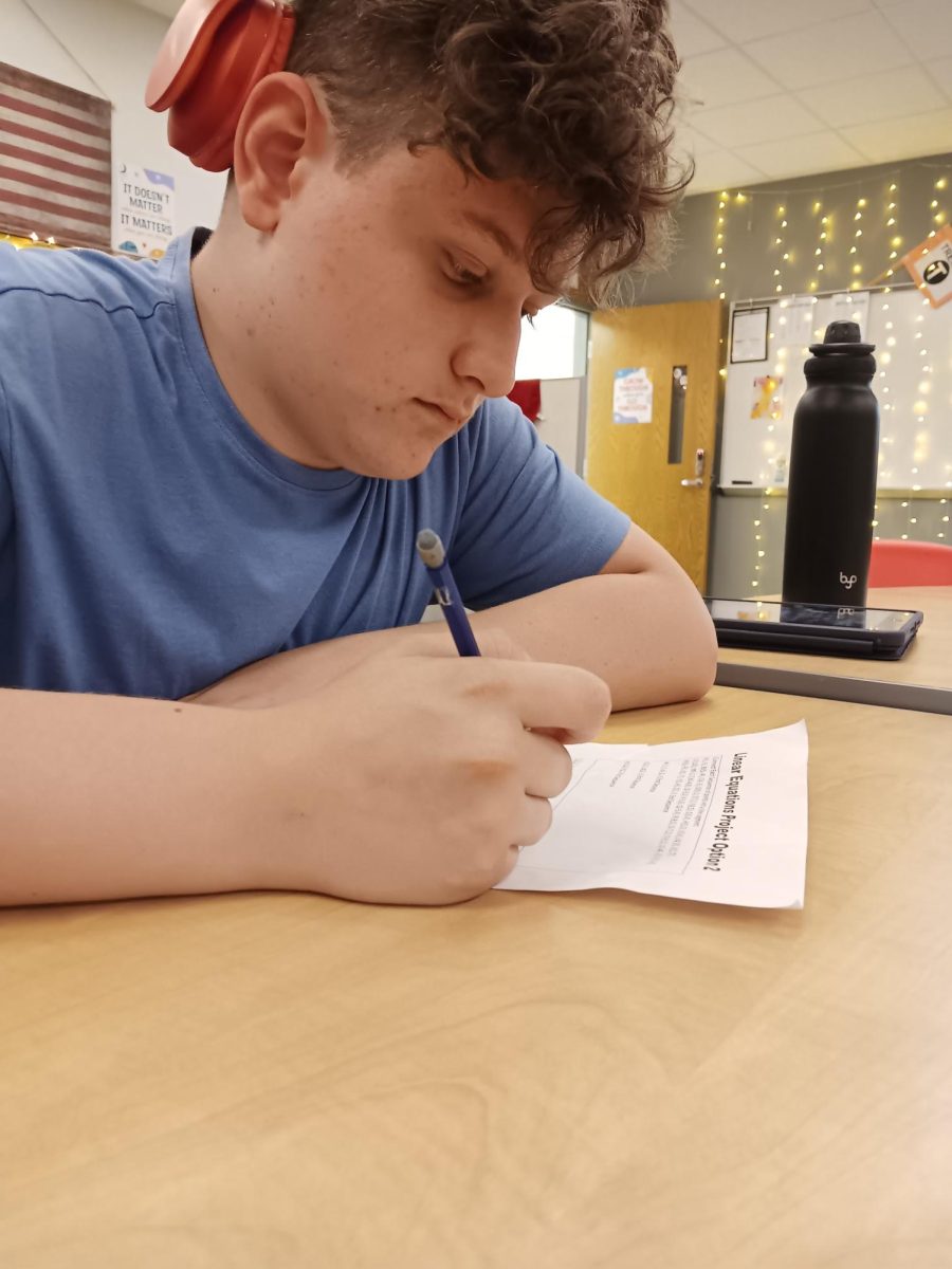 Sophomore Rey McClure works on Algebra II after lunch. The worksheet was on linear equations, which students can model on graphs to realize ther properties. "My favorite part of math is when we get to do graphs," McClure said. 