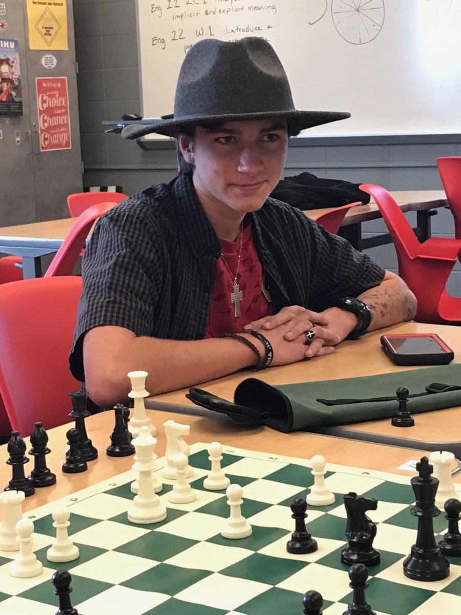 Dressed for a D&D session later that day, freshman Owen Henessey watches a chess match unfold during a Chess Club meeting. Henessey had previously been a apart of his middle school chess club since he was in 6th grade, and had made good friends in that time. "I like competing with kids that I'm familiar with," Henessey said. "It's pretty high up on my priority list, and I intend to stay for most of the year."