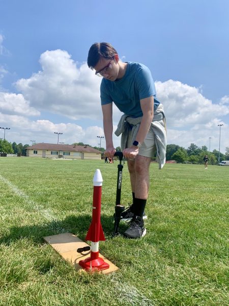 In an Honors Physics lab, sophomore Gavin Woods prepares to launch his rocket by pressing down on a bicycle pump. His classmates, also working with projectile rockets, were conducting their experiments to collect data for practicing calculations related to vertical motion. “We were measuring the time to see how long the rocket stayed in the air so that we could use that to calculate its speed,” Woods said. “We’re learning about vertical motion, so this lab helped us visualize that.”