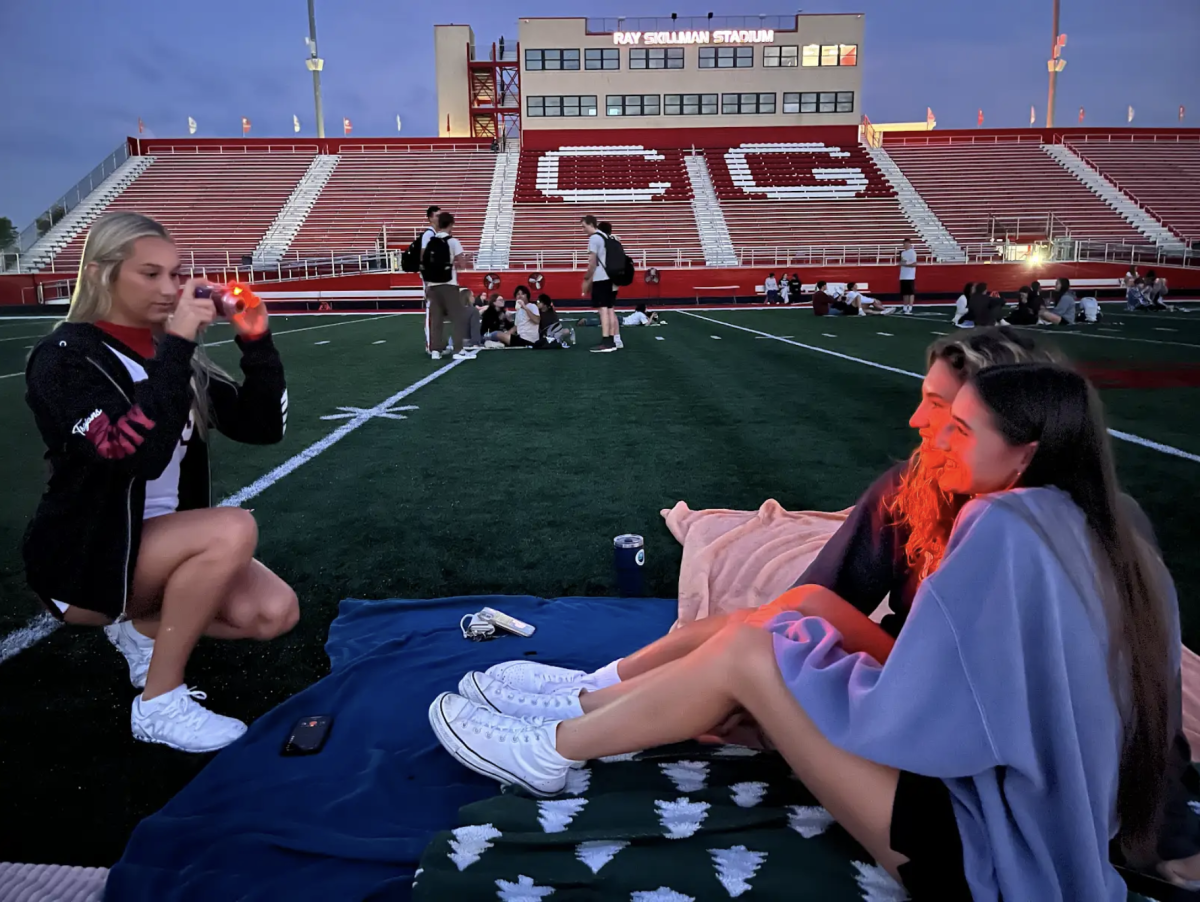 Seniors Olivia Werner, Marissa Pogue and Franny Podolsky take a picture during the senior sunrise. From 6 to 6:45 a.m., seniors had the opportunity to go to the football field, grab a donut and watch the sun rise. Students also had the opportunity to write a letter to their future self.  “I loved this activity because I got to make memories with my best friends and watch the sunrise,” Podolsky said. 