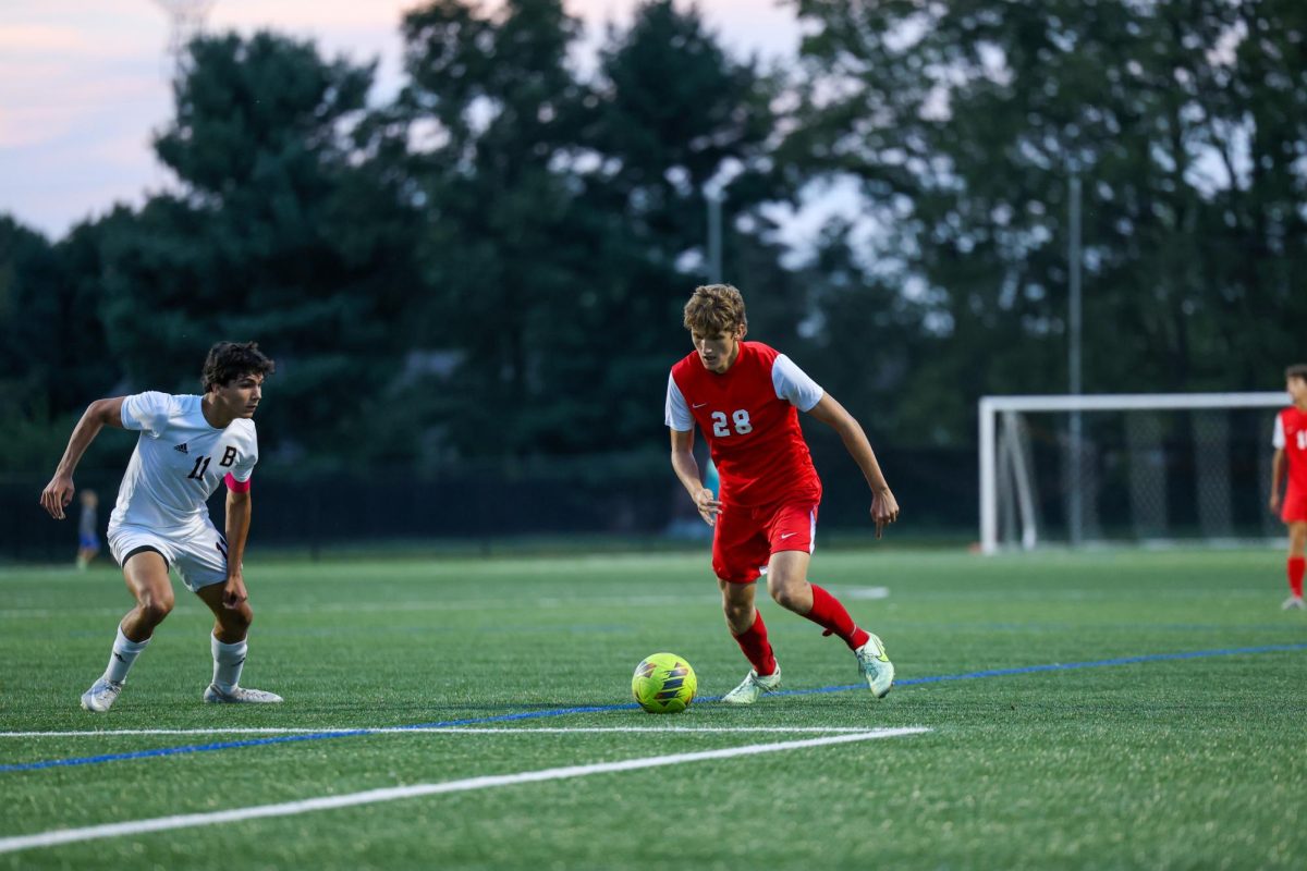 Junior Niekos Whitney takes on a Brebeuf defender in the Trojans' 2-1 victory.