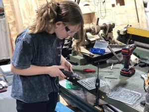 Sophomore Kaylee Holverson works on a poly-carbonate plate during a robotics meeting. Holverson also helps mentor elementary school children with robotics as well.