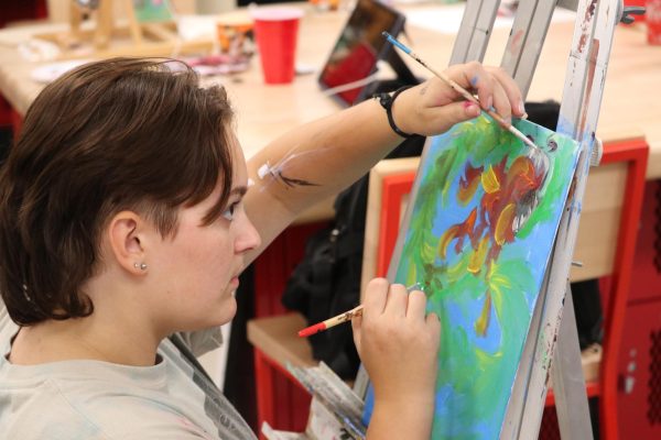 Senior Evie Miklos paints during the AP Studio Art Canvas Clash activity.