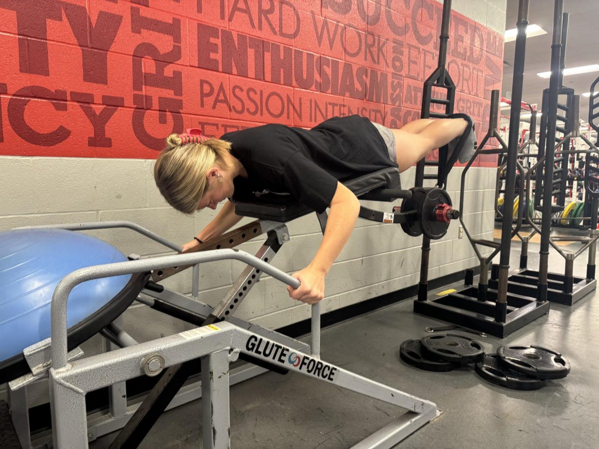 Senior Lyla Weir exercises her glutes and hamstrings using a machine in her 7th period weightlifting class. Athletes can use the class to help improve their performances. “In weights class, I feel pumped up to work out because Coach Mills has such a great environment,” said Weir.