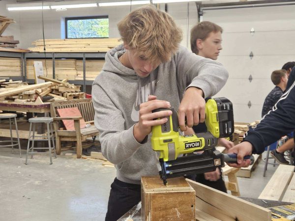 Sophomore Hunter Gradert uses a nail gun in Greg Werner's fourth period class. This week, students have been practicing with nail guns to make birdhouses in class. “I like this class because you get to do a lot of hands-on projects,” Gradert said.