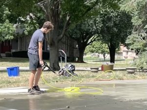 Sophomore Josh Prather works on a driveway with his pressure washing tools.