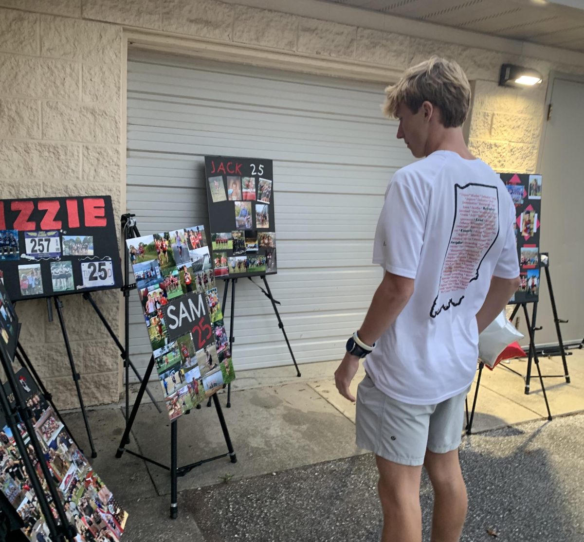 During the Senior Night Cross Country meet, Senior Sam Heinemen looks at his Senior Night poster at the home course on senior Night. Senior Night celebrates and honors the graduating seniors for their hard work and dedication to their sport throughout high school. “For me, Senior Night is a chance to be recognized for all the years I have put into the team,” Heinemen said. “It is also a farewell to those who have been with me on the journey.”