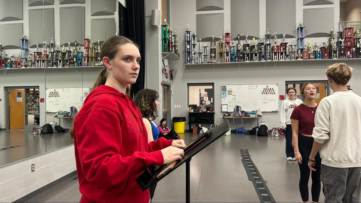 In the choir room, junior Claire Lollar assists the ensemble of Bye Bye Birdie to clean their choreography for One Hundred Ways Ballet.