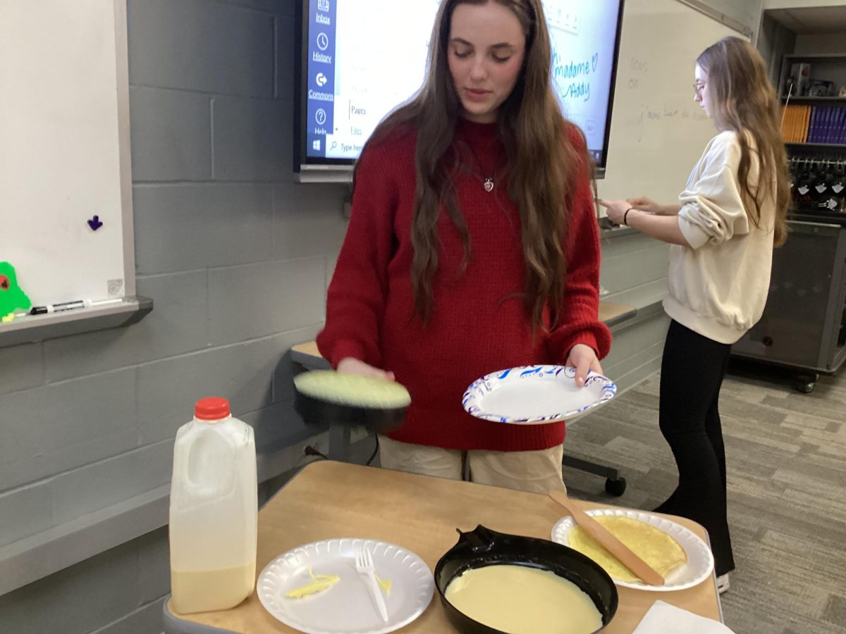 Junior Liliana Benchino makes a crêpe in French class. Students brought in French food related to thier vocab unit. “We are having a French potluck in French class today,” Benchino said. “We are going to eat it and work on our assessment videos. This relates to our study because our unit is over hotels and how the food is different in America and in France.”