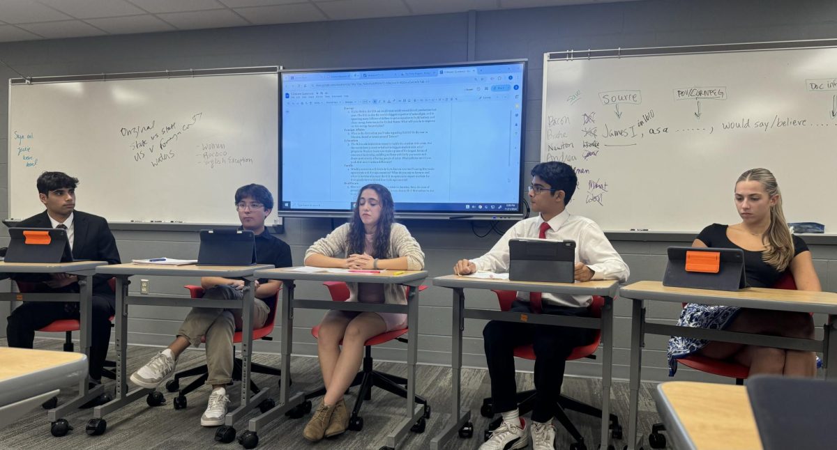 Seniors Rupesh Vats, Ethan Herron, Brooke Ault, Gourav Pany, and Reese Dunkle participate in a mock presidential debate during Mrs. Terrell’s 10th period AP Government class. The students participated as part of their political party project where each candidate has a group of students create mock campaigns against each other. “It was a really fun experience being able to simulate an aspect of real politics. I had a good time debating my peers," Dunkle said.