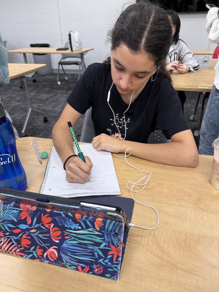 Junior Penelope Saha solves problems placed around room 552 during the math NHS meeting. Students worked to solve the problems for the correct answers, which helped them build a paper turkey. “My favorite part about math NHS is engaging in one of my favorite subjects with all of my best friends,” Saha said.