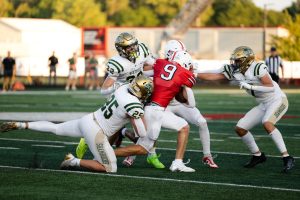 Senior Brevin Holubar attempts to break through a tackle during the Trojans' game against Westfield earlier this season.