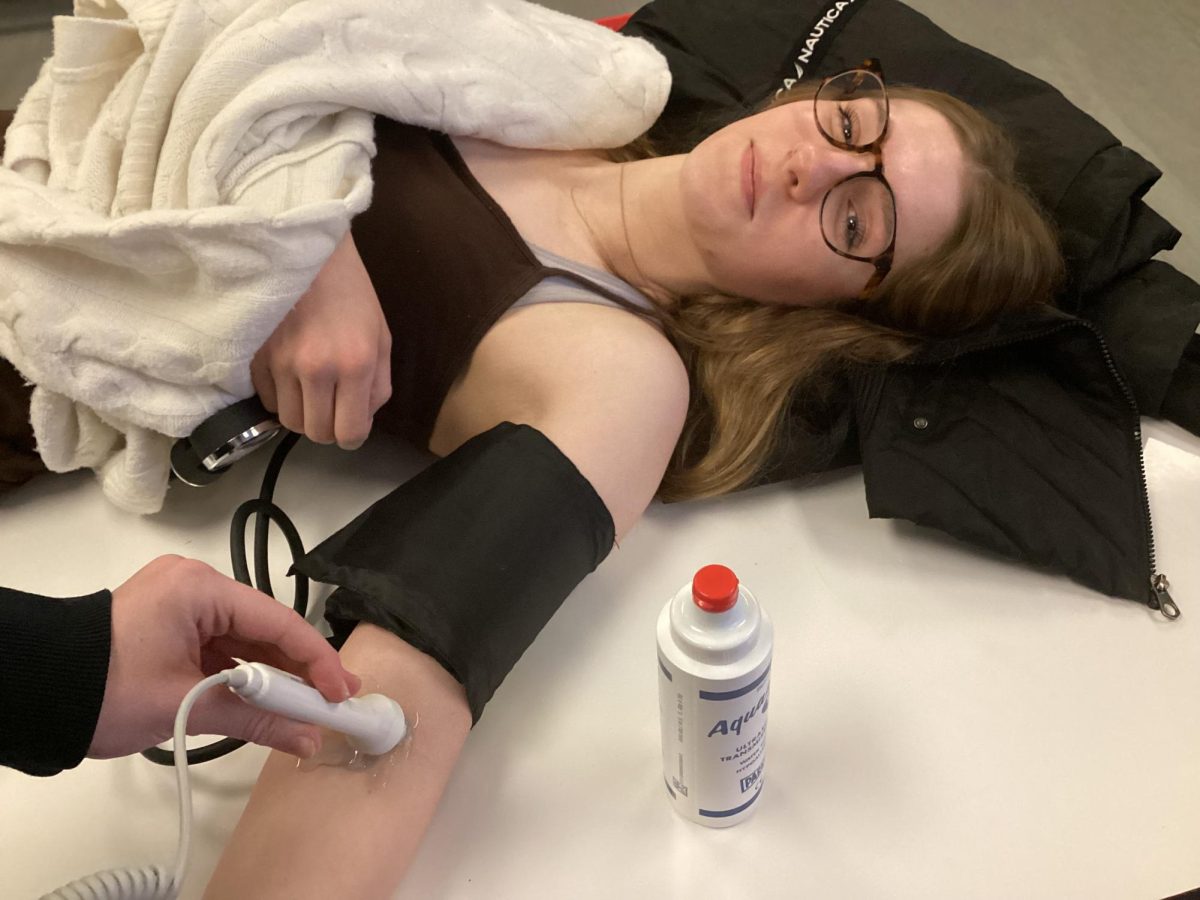 As part of Andrea Teevan's Human Body Systems class, sophomore Keeley Shields undergoes her ABI (Ankle-Brachial Index) test during first period. This test was crucial for assessing blood flow in her limbs, allowing her to gain a deeper understanding of the circulatory system and its significance within the human body. The test shows the difference in blood pressure between the ankle and arm. “I could use this later on if I decide to go into cardiac health, because I’m getting a early look at the process of this field,” Shields said. “We are learning about blood flow and how to check our pulses which is important when it comes to the medical field.”