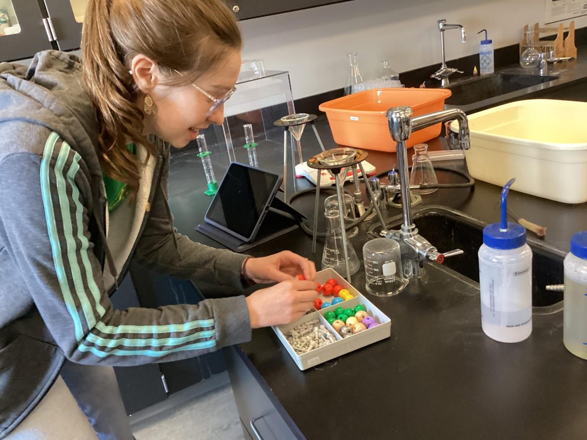 In Timothy Eddy’s honors chemistry class, sophomore Eleanor Kallio searches for pieces to make a H2O molecule. Students learned how to efficiently create molecules determining on its Lewis structure. “It doesn't really do much good to know what the molecule is if you don't really know what it looks like or why it looks the way it does,” Kallio said “Visualizing molecules is a very effective way to see what it is that you're doing because then it helps you understand the structure of the molecule, like what the molecule is made up and then you can branch out into other areas.”