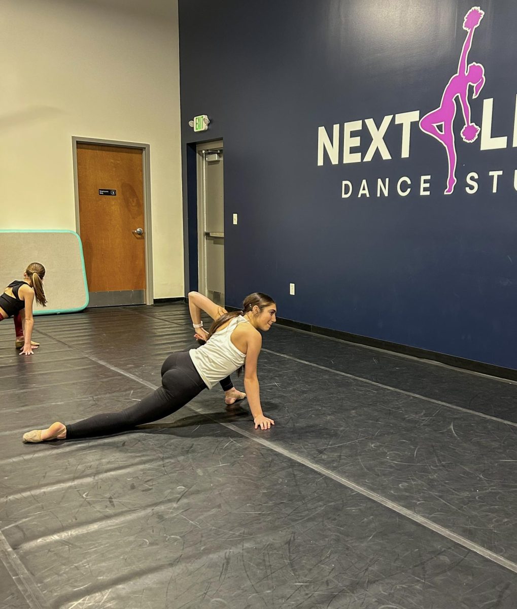 Freshman Esther Greenwood stretches as she prepares for technique class at Next Level Dance Studio. Owner Katie James, Center Grove Varsity Dance Team assistant coach and choreographer, opened the studio to help dancers prepare to dance at the next level. The studio just opened in the Center Grove area and offers classes to dancers of all ages and skill level. 