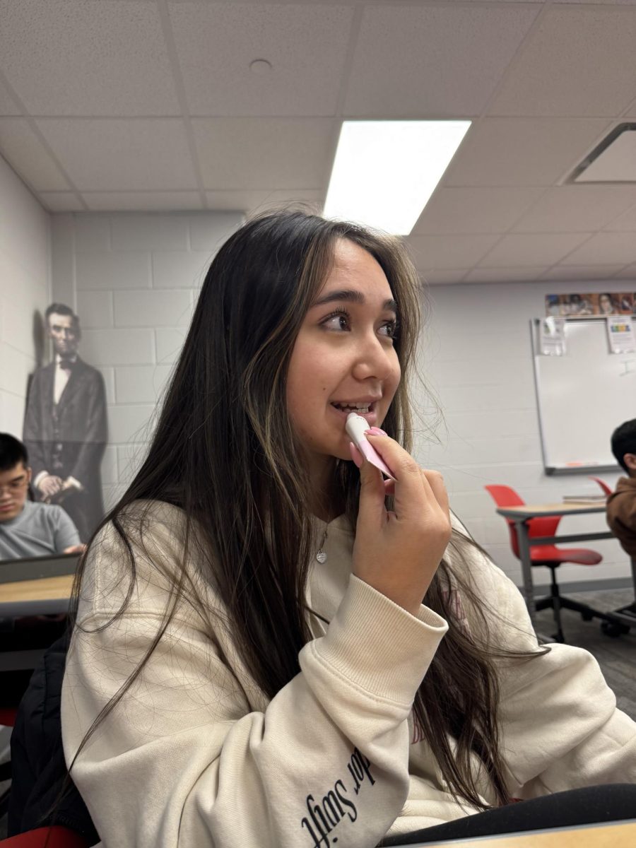 During Sarah Terrell’s 10th period AP Government class, senior Macie Pascual applies her new Glossier The Balm Dot Calm Balm, which she received as a Christmas gift. “It is really hydrating for my lips and goes on smooth,” Pascual said. “I would recommend it because it’s affordable and long-lasting.“