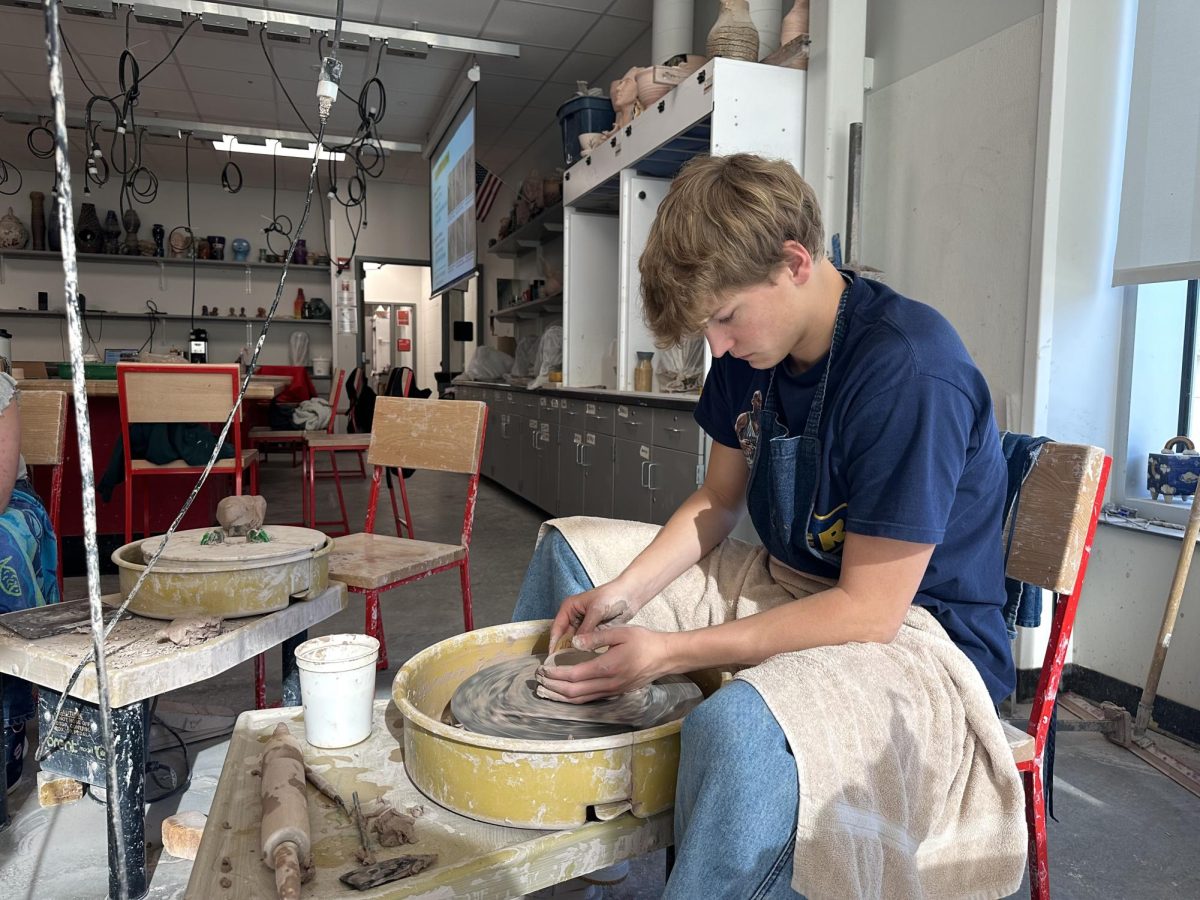 Isaac Lewis works diligently in pottery class, shaping a small bowl on the spinning clay wheel. Earlier in the semester, students learned basic techniques for molding clay and have now progressed to creating functional pieces. 