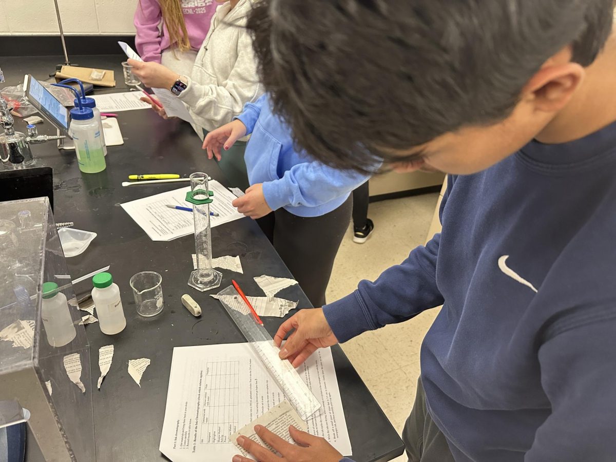 Freshman Sid Shenoy does a slime lab for his Honor Chemistry class. The class used slime and silly putty to help detirmine the polarity of various inks. “The purpose of this lab was to make slime in order to learn about molecular forces and polarity,” Shenoy said.