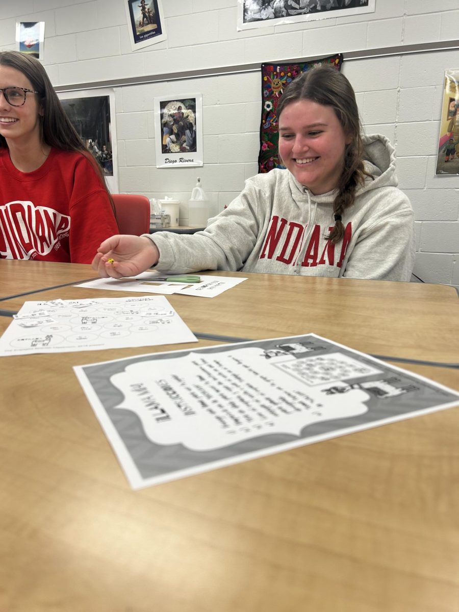 Junior Celia Yurs rolls the dice during an activity in Spanish 4. Students in Kristi Fleck’s class worked with their table partners on a board game to help them understand the imperfect subjunctive tense in Spanish. “We were playing a conjugation game, it helped my conjugation skills,” Yurs said.