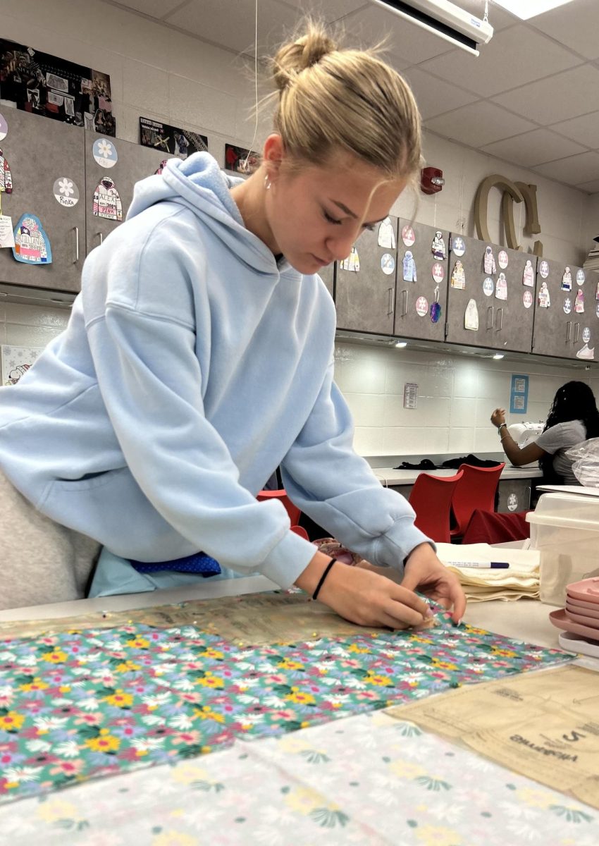 Senior Grace Van Dyck spends her AIM working on her bag project for fashion class. Van Dyck had to brainstorm ideas for a business, and work that out for the class. “I’m working on my final project for Fashion 3. For that class, we had to have an idea for a business, and I’m really into bags,” Van Dyck said. “I make makeup bags, so I’m making one for college that has lots of pockets for small items. I also want to incorporate a keychain that’s attached to the bag as well.”
