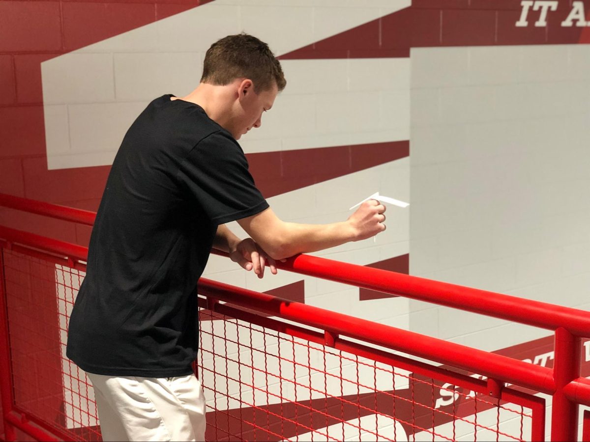 Senior Quinn Smith drops a paper helicopter during his AP Statistics experiment on Friday.