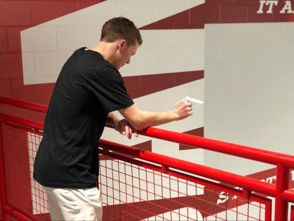 Senior Quinn Smith drops a paper helicopter during his AP Statistics experiment on Friday.