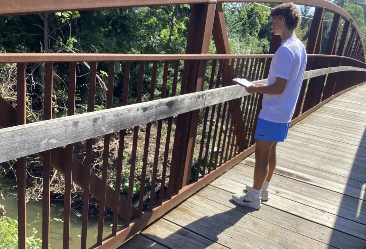 During Brian Weidman’s AP Environmental Science class, junior James Ignaut looks at Honey Creek, which flows close to the school. Students saw examples of how the school has altered the environment. “I really liked that we got to get out of class and go do a hands on lesson," Ignaut said. "It was really neat being able to see some real examples right here in the school”. 