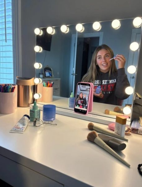 Junior Annabelle Schembra films a TikTok video while doing her makeup