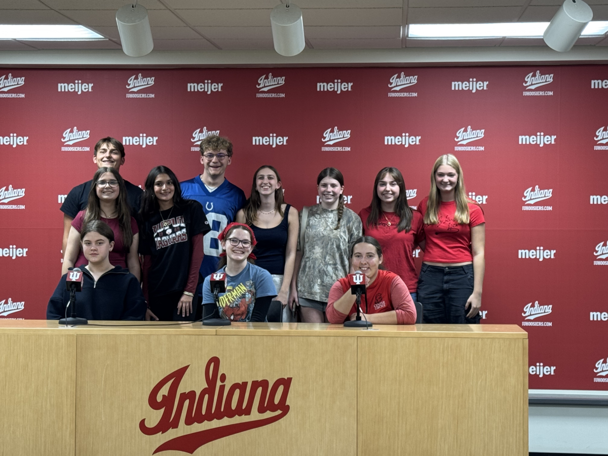 Pubs Club students pose in the press room of the Mark Cuban Center for Sports Media and Technology.
