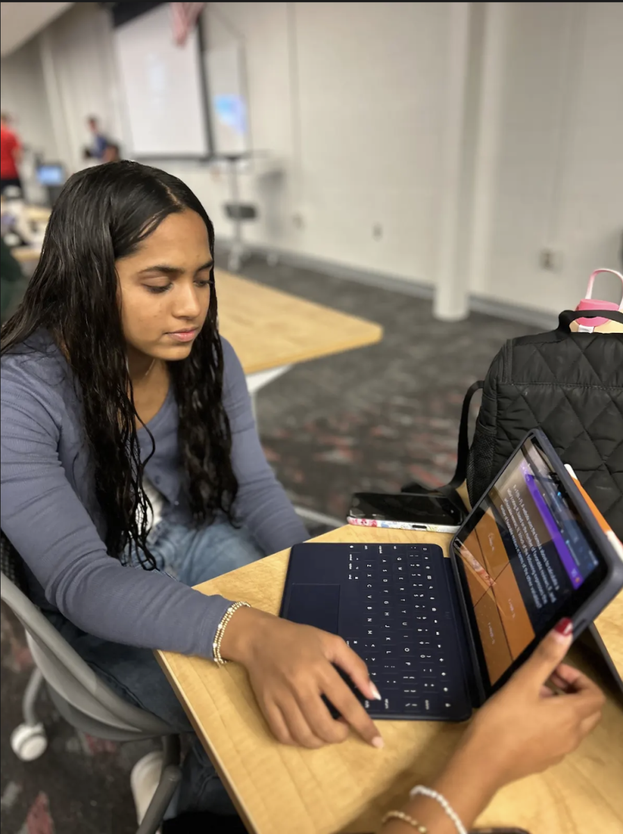 Collaborating with her friends, sophomore Prajvee Chavan completes a halloween themed PSAT blooket at the October Math NHS meeting. With sophomores and juniors taking the PSAT next week, Math NHS chose this activity to provide a way for students to review the material in the math module. “This blooket has helped me learn the different types of questions that are asked on the PSAT, and it has also prepared me to manage my time while taking the test,” Chavan said. “This is my first year in Math NHS, but the blooket activity has been my favorite thing we’ve done so far.”