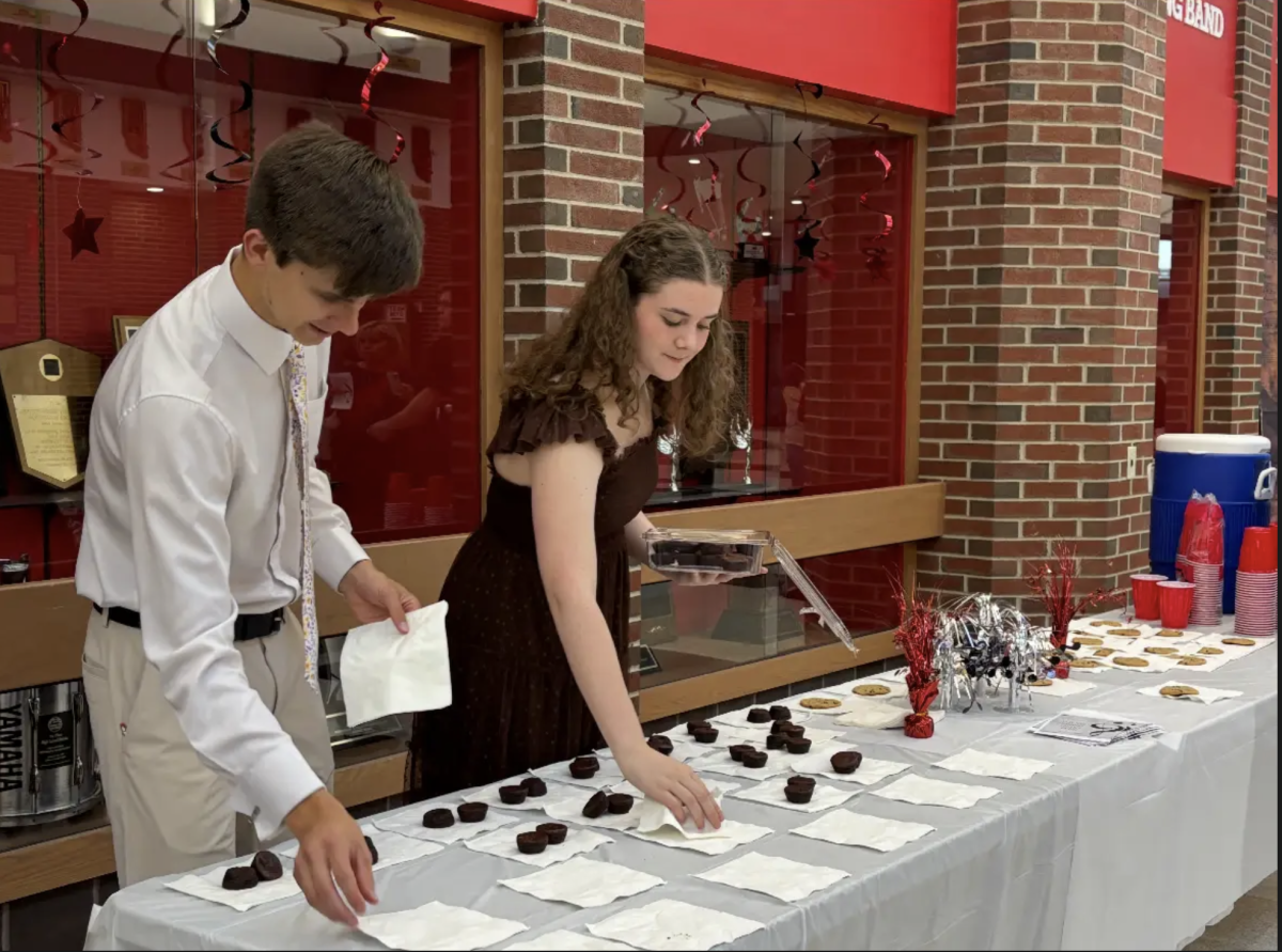  Seniors Audrey Johnston and Jeffrey Sweeny restock the refreshments at the Tri-M Music Honors Society meeting. Along with Annabelle Kemerling the two are a part of the leadership that planned the ceremony. “The most difficult part about planning was getting information out to the inductees, and making sure everyone had filled out forms for the ceremony,” Johnston said. “The set up for the ceremony went well. There was a little problem when the lemonade cart broke and spilled everywhere, but we got it cleaned up quickly with the help of the janitors.” 
