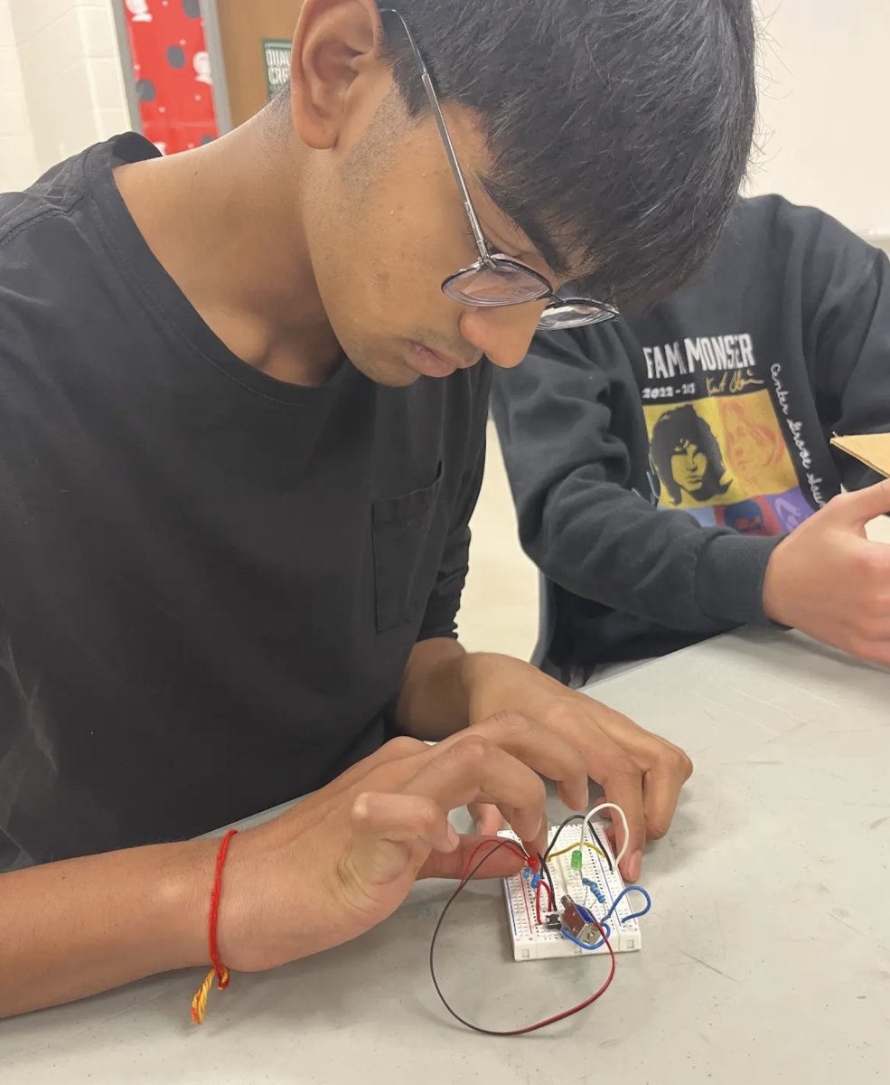 After testing his circuit, junior Aksh Ranjan adjusts the wires to create a new circuit. In Principles of Engineering, students had the opportunity to build prototype vaults powered by circuits that they built themselves. “You have to consider a lot more when you’re building a physical circuit,” Ranjan said. “If you give a component too much current, you could short it out. But at the same time, you have to give it enough current for it to work. It’s a careful balance that you don’t consider when you’re making a theoretical circuit.”