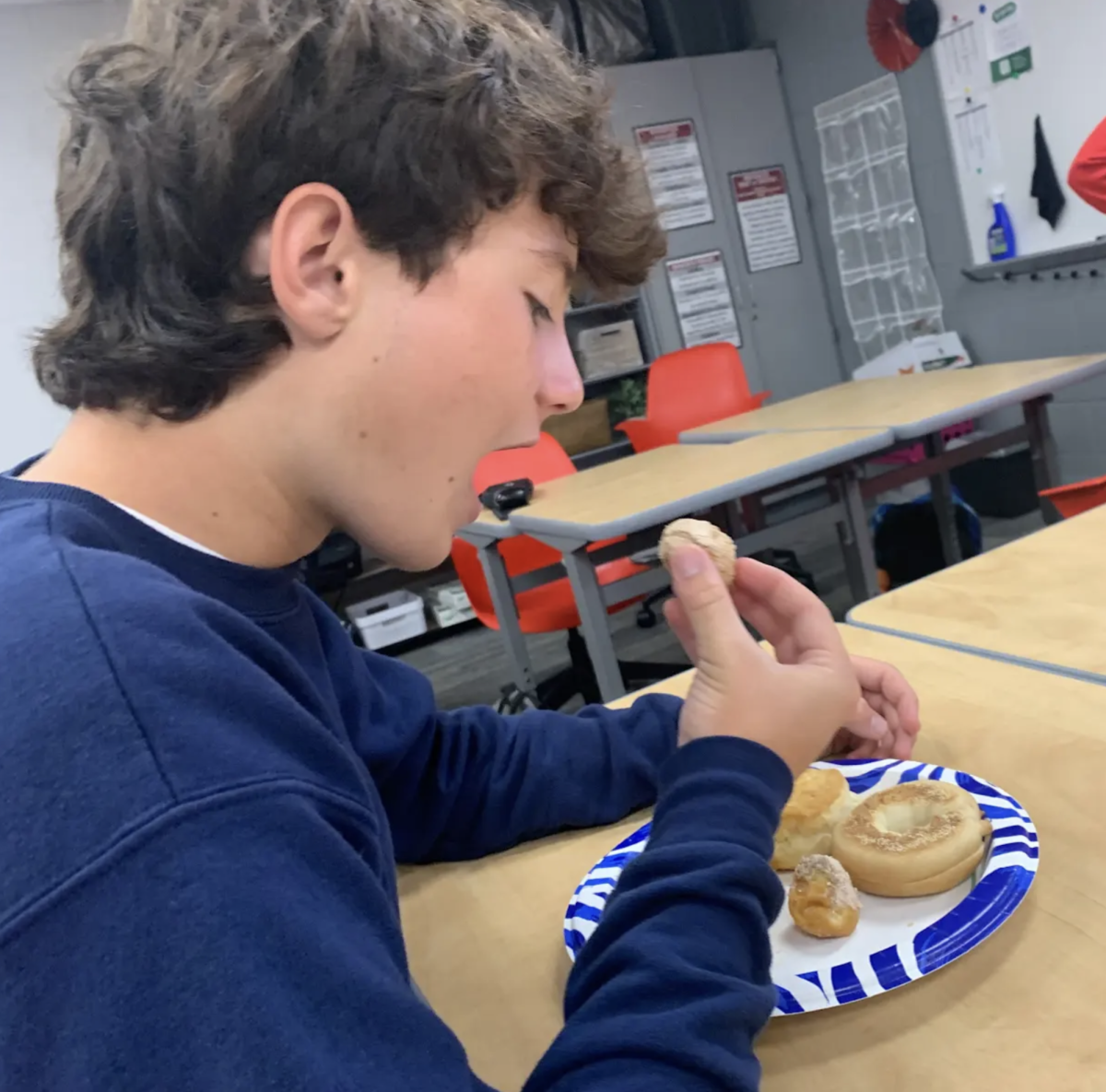 "In teacher Kathy Long and Gina Constantine’s Junior STAR Class, J Stout enjoys a snack. At this STAR party, the students agreed to bring breakfast foods. There were donuts, fruit, egg casserole, bagels, and biscuits and gravy. “We have STAR parties that happen right before long breaks,” Stout said. “My favorite part about STAR parties is growing a closer connection with the people around me through enjoying food with others.”