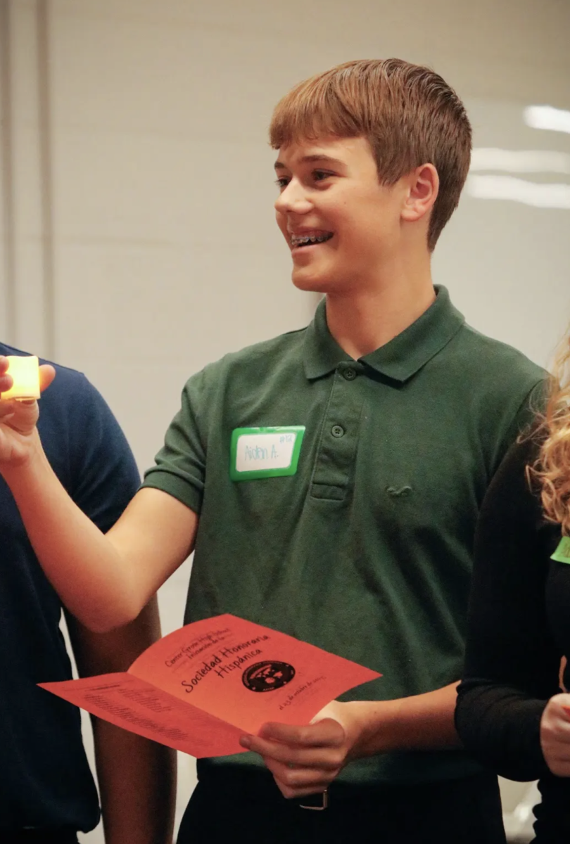 While showing his friends his newly lit Spanish National Honors Society Induction Ceremony candle, sophomore Aiden Addy smiles while becoming an official member of the club. “I joined the club to get more involved, especially with my academics,” Addy said. "I was happy with my induction." In meetings once a month, Spanish NHS does Spanish games and activities that relate to the culture and language and go on a few field trips throught the year.