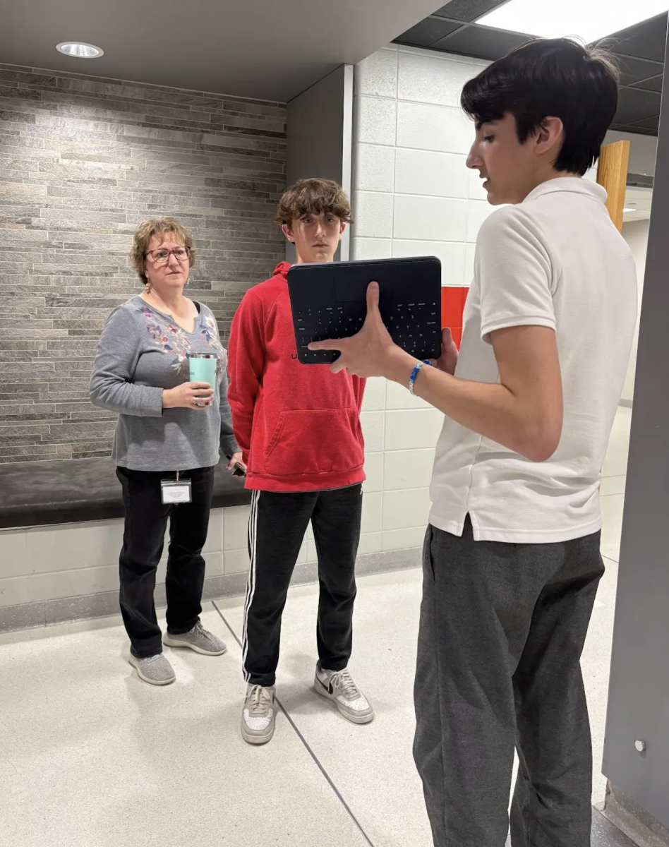 During Honors English 10, sophomores Gavin Brodecker and Mason Smith present information in preparation for the To Kill a Mockingbird unit while teacher Beth Strodel looks on during her last day of teaching English. On Thursday, Strodel, who has taught both Honors 10 and English 9, said au revoir to the English hallway and moved one floor up to the World Langugae hallway to teach French. "With Mrs. Vitz leaving, a person capable of teaching French was needed, so I stepped in," Strodel said. "My first Masters degree was actually in French Literature. I taught all levels of French including French 1 all the way through AP French." 