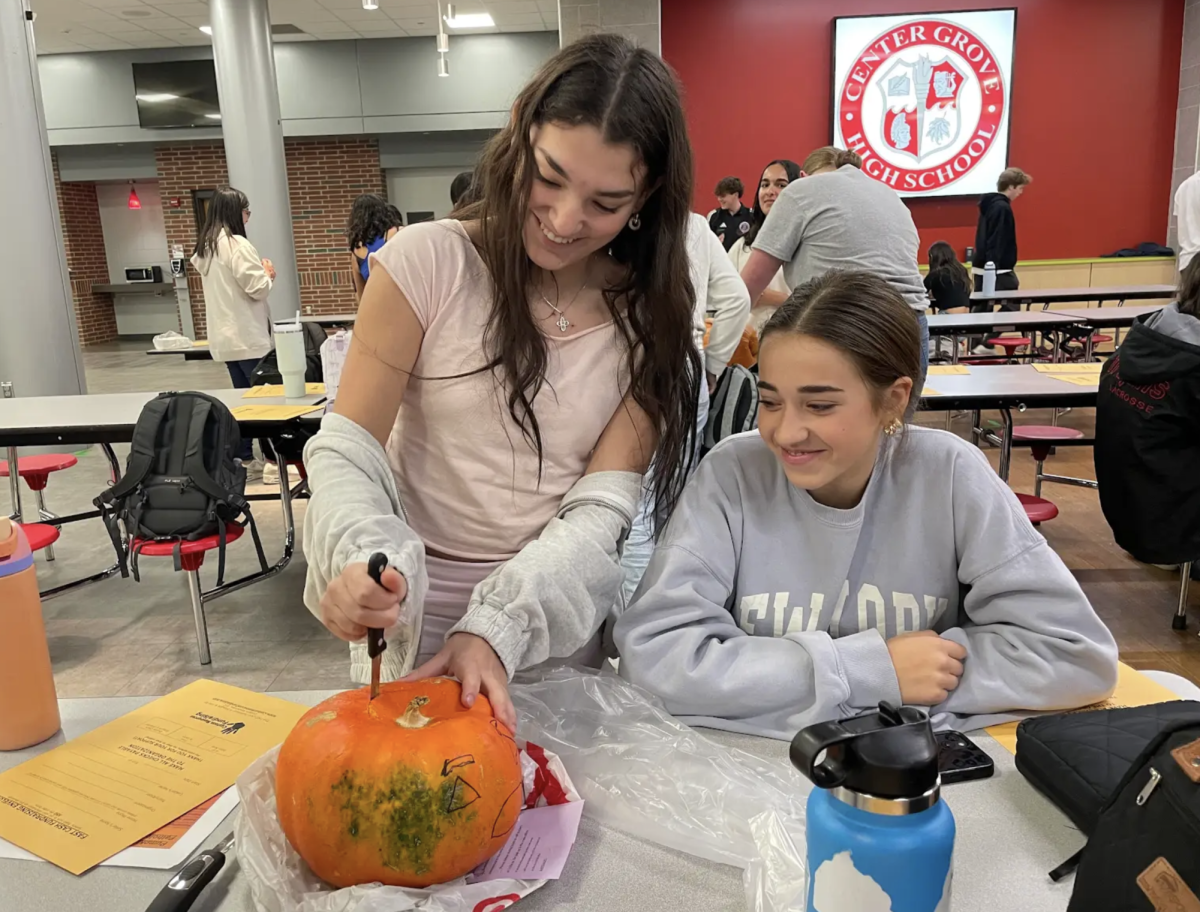 Cutting out the top of the pumpkin, sophomores Lillianna Moreno and Sophia Vassar participate in the HOSA pumpkin carving contest. Members researched a disease and included it in their design. “Our goal was to illustrate the signs of lyme disease on our pumpkin,” Moreno said. “My favorite part was getting to work with my team on something both educational and fun.” 